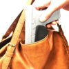 hand gun with trigger guard being placed in a purse
